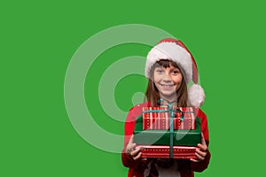 A little smiling girl in a Santa hat is holding a lot of gift boxes. New Year's gifts for Christmas. 2023. Isolated