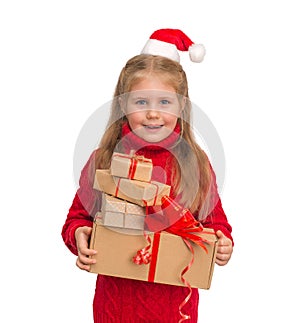 Little smiling girl in Santa hat and sweater holding many Christmas presents isolated on white background