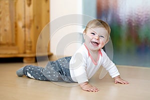 Little smiling happy cute baby girl learning to crawl.