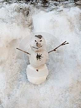 A little snowman made with snow and pieces of twigs