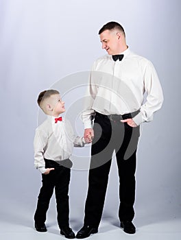 Little son following fathers example of noble man. Gentleman upbringing. Visit theatre dress code. Father and son formal