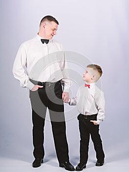 Little son following fathers example of noble man. Gentleman upbringing. Visit theatre dress code. Father and son formal