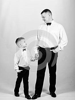 Little son following fathers example of noble man. Gentleman upbringing. Visit theatre dress code. Father and son formal