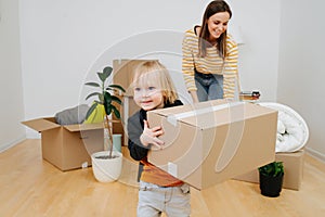 Little son helping mother to pack, they are moving out from an old apartment