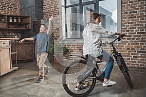 Little son and his beautiful mother having fun and riding bike