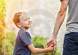 Little son hold his father for hand