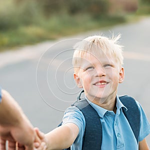 Little son holding father`s hand and smiling.
