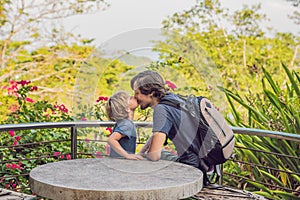 Little son kissing his father outdoors in spring park