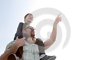Little son sits on his father`s shoulders