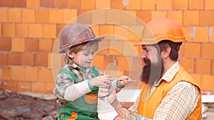 Little son worker erecting a brick wall. Boy play as builder or repairer. Son helper. Child dreaming about future career