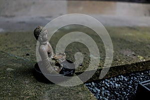 Little statue of the Gautama Buddha in front of burnt coals