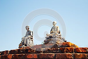 Little stone statues installed on a brick wall in Sukhothai Thailand