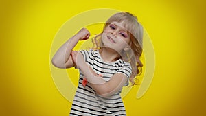 Little strong kid child girl showing biceps and feeling power strength, energy to gain success win