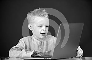 Little student boy using laptop computer in school class. Little funny programmer.