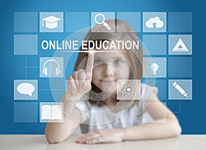 Little student girl choosing icon on virtual touch screen. Baby using a touch screen interface. Digital learning. E-learning