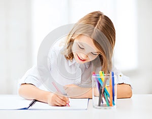 Little student girl drawing at school photo