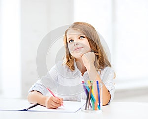 Little student girl drawing at school