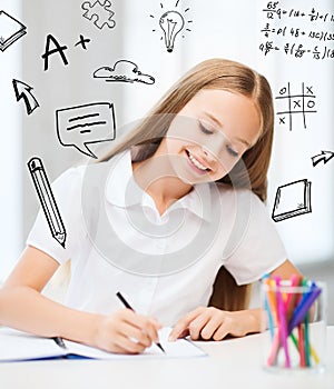 Little student girl drawing at school