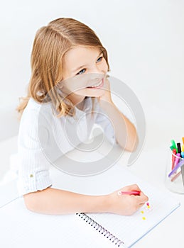 Little student girl drawing at school photo