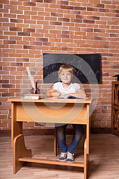 Little student girl sitting at a school desk and studying math. The child is doing homework. Preschool education