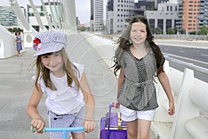 Little student girls going to school in city