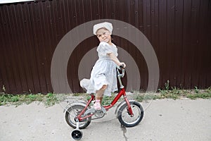 Little stylish girl riding bike. Kid on bicycle. Child enjoying bike ride