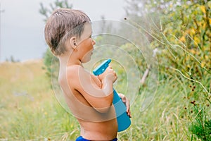 Little surprised boy sprays water