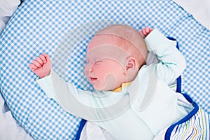 Little swaddled baby in white bed