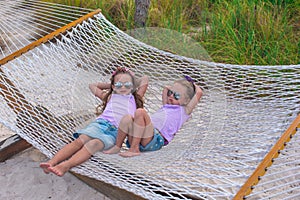 Little sweet girls relaxing in hammock on summer