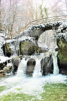 Mullerthal, Luxembourg - January 2024 - Schiessentumpel Waterfall under snow