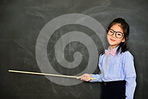 Little teacher using stick pointing chalkboard