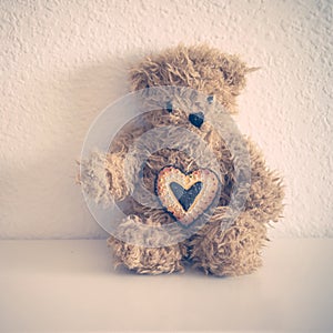 Little teddy bear sit down with heart cookie