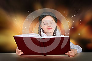 Little teen girl reads magical fairy tutorial book smiling