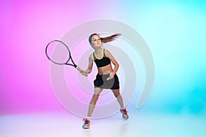 Little tennis girl in black sportwear  on gradient background in neon light