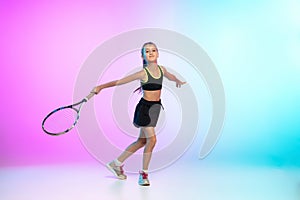 Little tennis girl in black sportwear  on gradient background in neon light