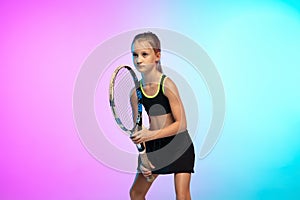 Little tennis girl in black sportwear  on gradient background in neon light