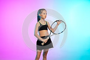 Little tennis girl in black sportwear  on gradient background in neon light