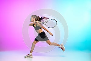 Little tennis girl in black sportwear  on gradient background in neon light