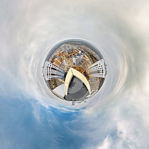 Little tiny planet from roof of multi-storey building with aerial view of construction residential quarter, white clouds and soft