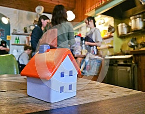 Little tiny soft toy house model in a cosy restaurant