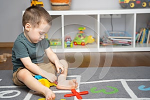 A little toddler boy 2.5 years is playing with a toy helicopter, assembling and disassembling it. Educational toys for kids.