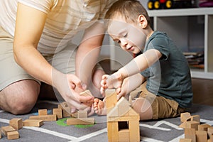 Little toddler boy 2,5 years playing wooden blocks with dad. Spending time with children.