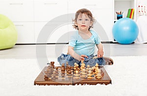 Little toddler boy with chess board