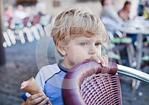 Little toddler boy eating ice cream in cone