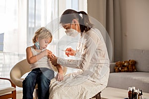 Little toddler boy, getting injection in consulting room from pediatrition