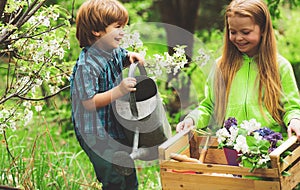 Little toddler boy and girl gardening and having fun in spring yard. Pretty cute kids working and playing in beautiful