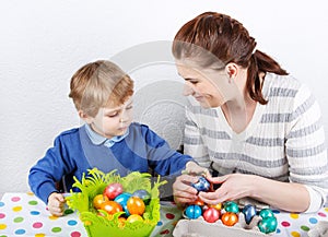 Little toddler boy and his mother being happy about selfmade Easter egg in kindergarten