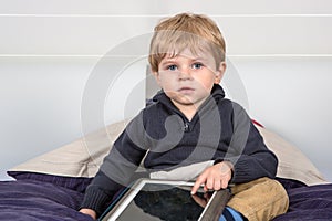 Little toddler boy playing with tablet pc