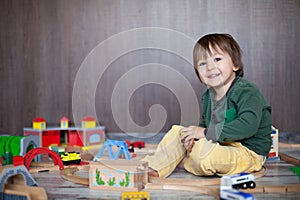 Little toddler boy playing with wooden railway