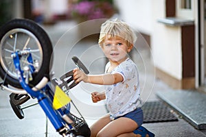 Little toddler boy repairing his first bike